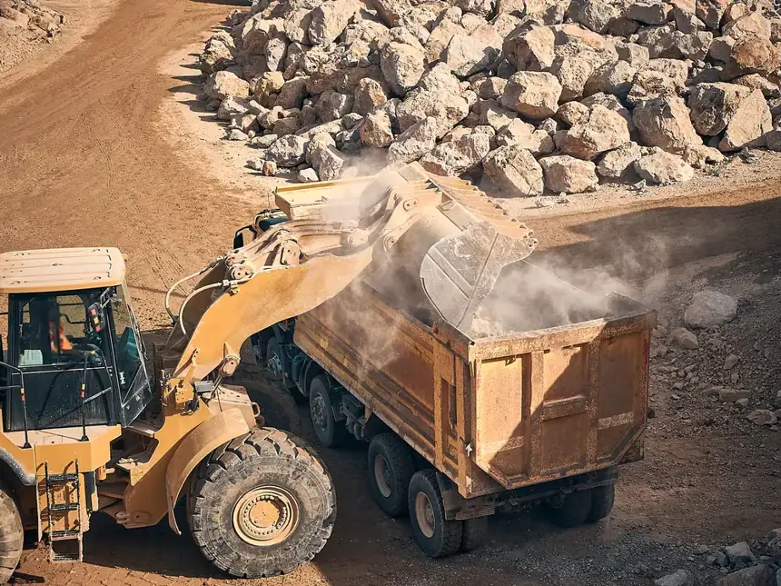 Cargador llenando una volqueta con piedra