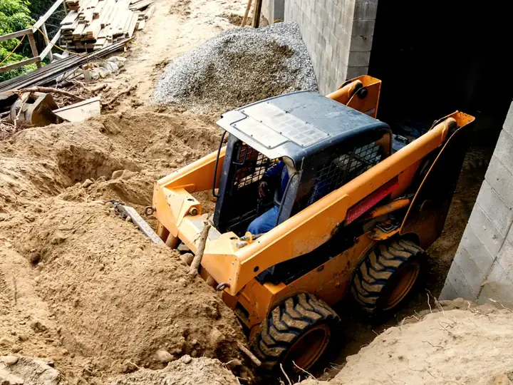 Minicargador moviendo tierra