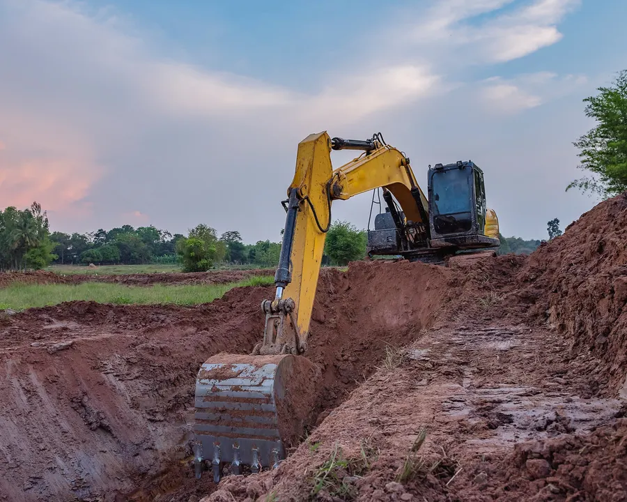 Excavadora abriendo una zanja en terreno rural